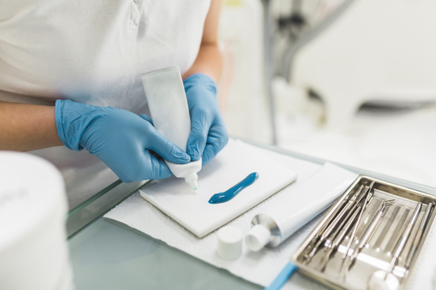 Dentist preparing resin for prostheses